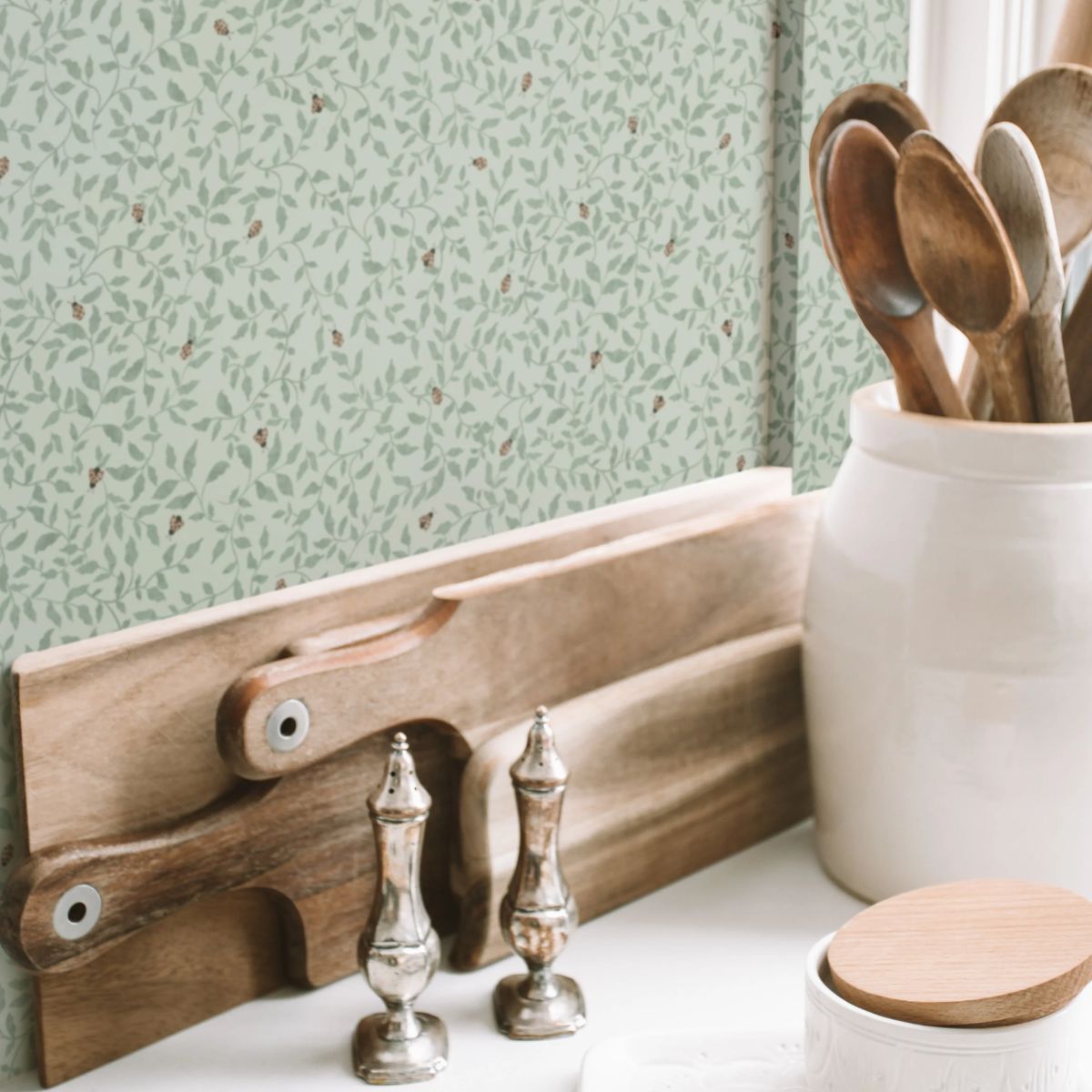 Ladybirds Sage behang van Summer Gray op een muur – vrolijk lieveheersbeestjesmotief in Sage tinten