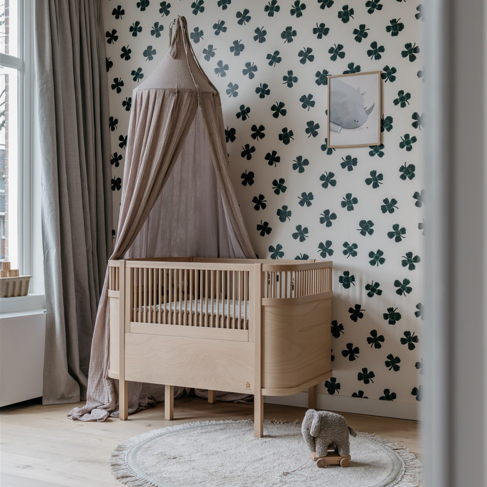 Rustige babykamer met groen botanisch behang met klavers en natuurlijke kleuren inspiratie
